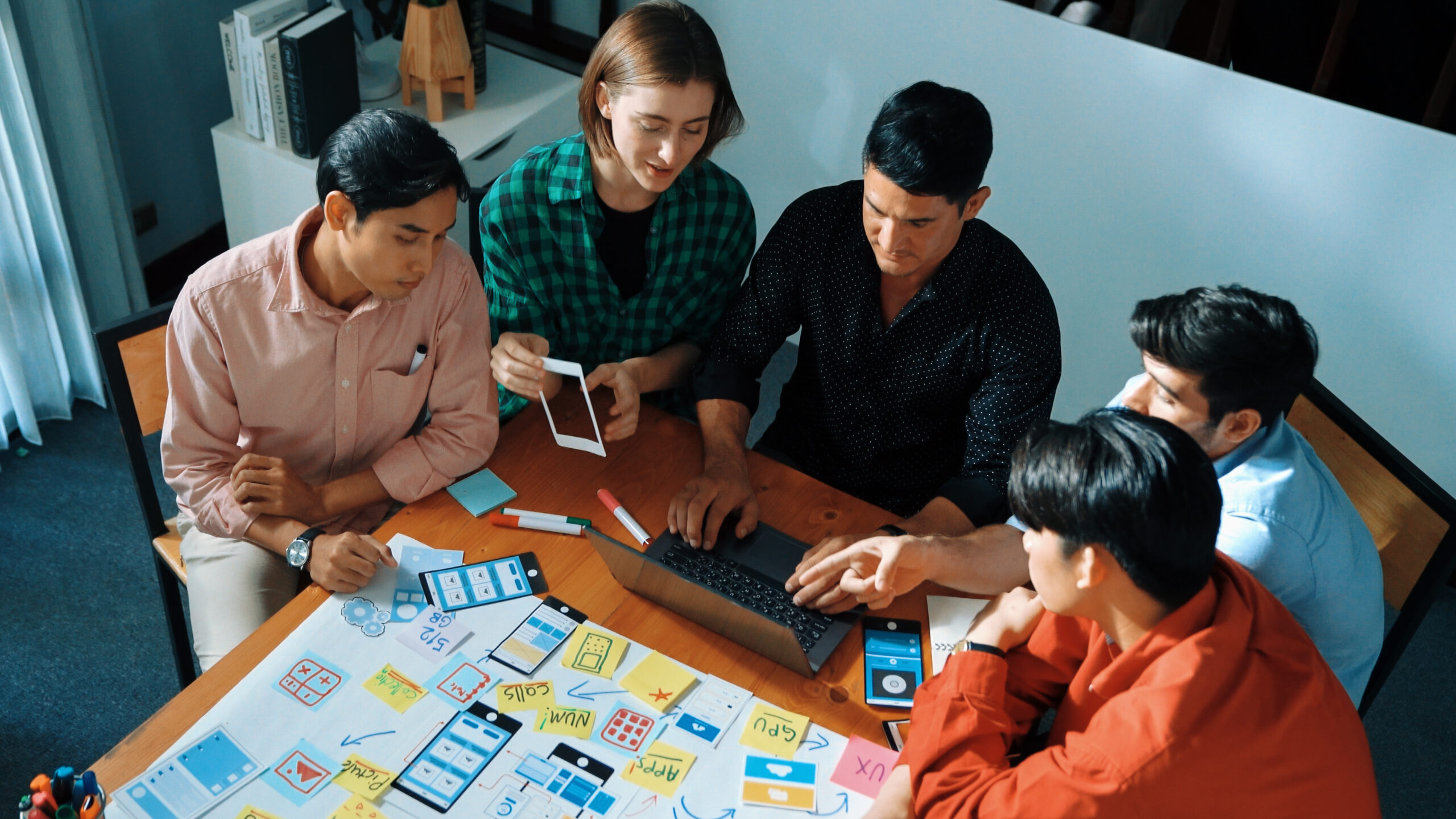 Top view of diverse business people brainstorming idea by using mind map. Creative marketing team looking at data analysis from laptop screen while manager choose idea and show to team. Convocation.